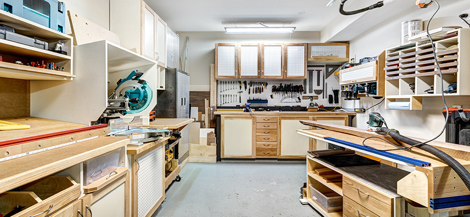 garage workshop with light tan and white cabinets